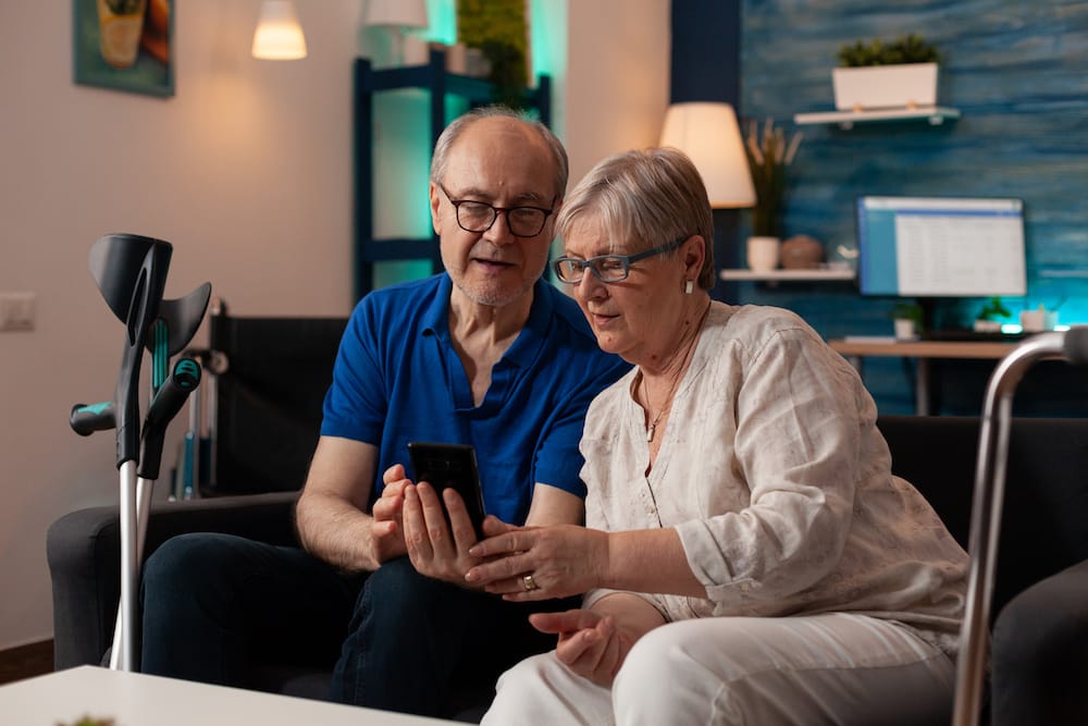 Älterer Mann und Frau schauen gemeinsam in Smartphone